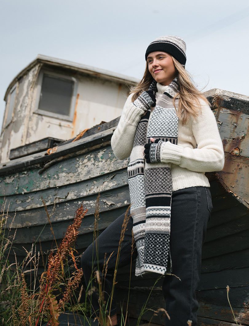 Girl wearing a black, white and neutral long fair isle scarf